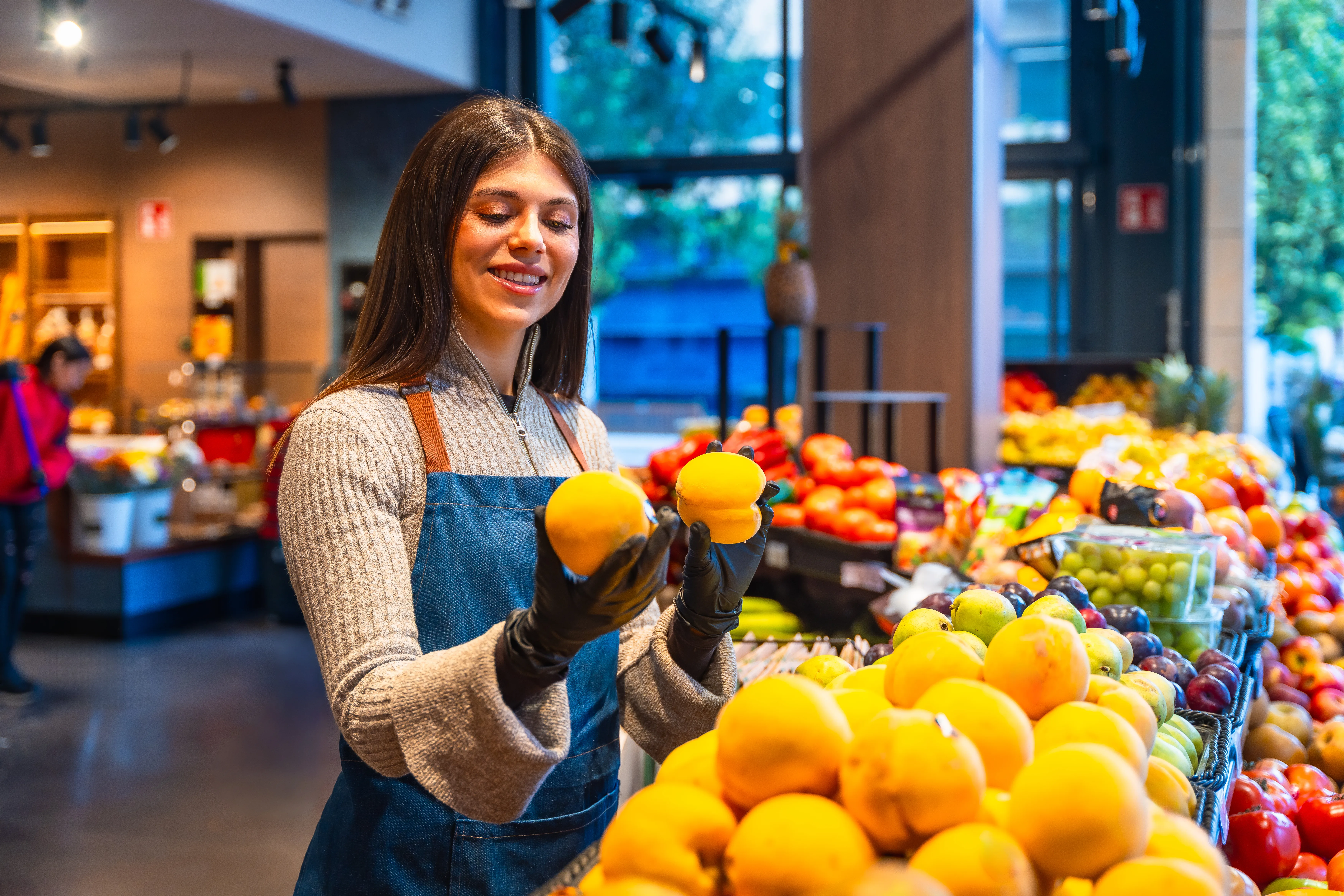 Grocery store employee arranging fresh produce for retail display